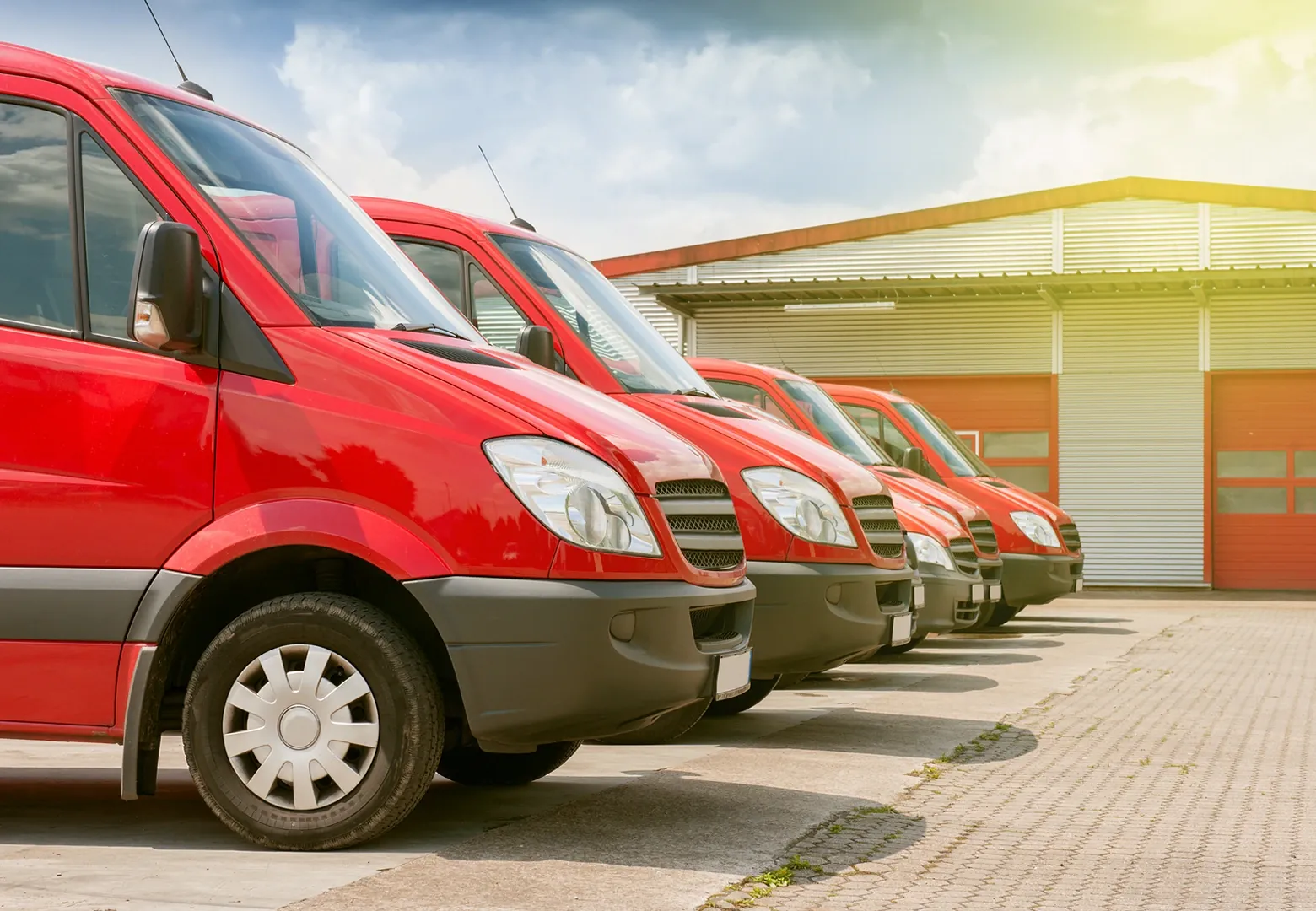 A fleet of red delivery vans lined up outside a depot